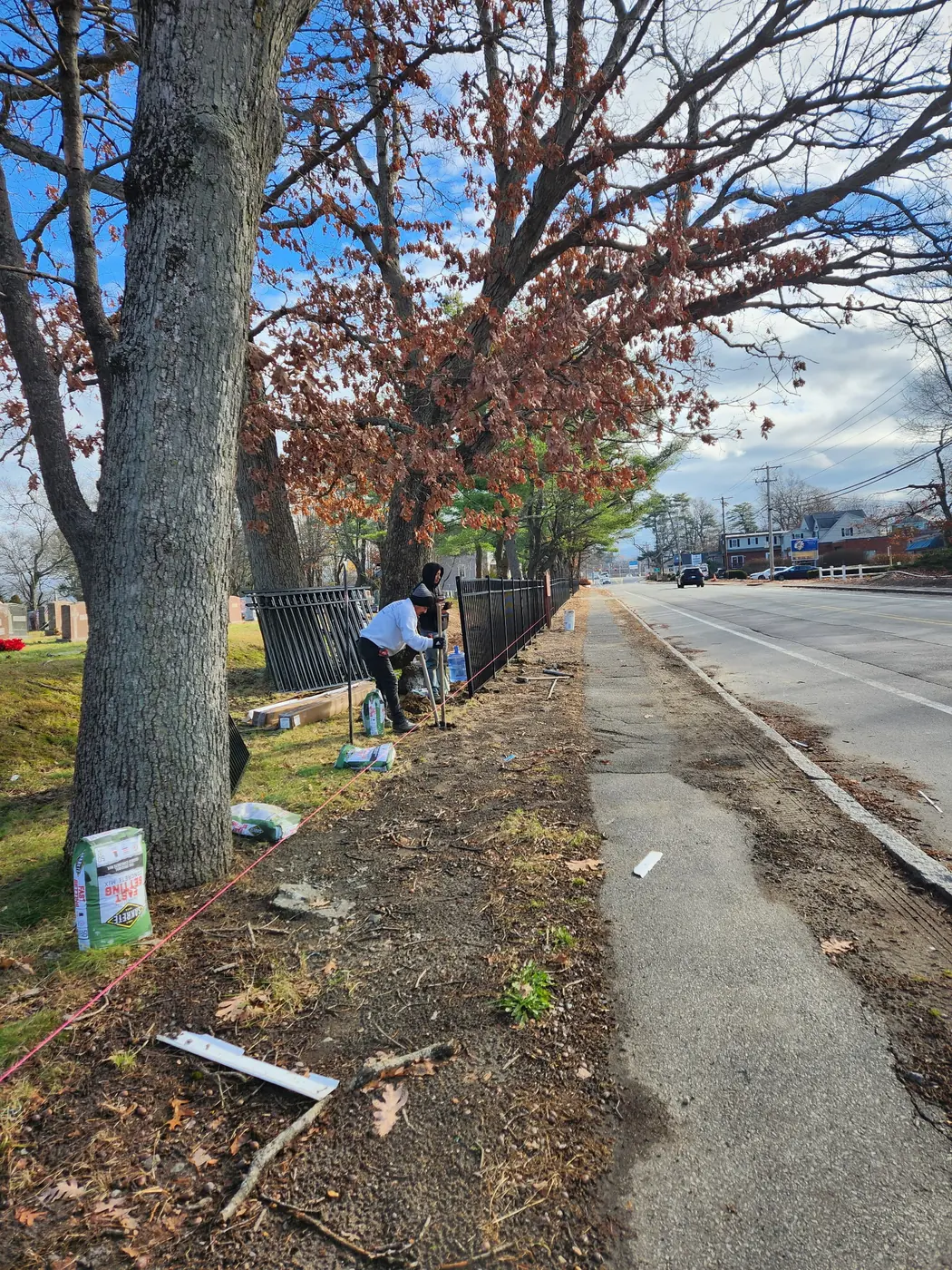 Matul Fence crew installing black aluminum panels along a sidewalk